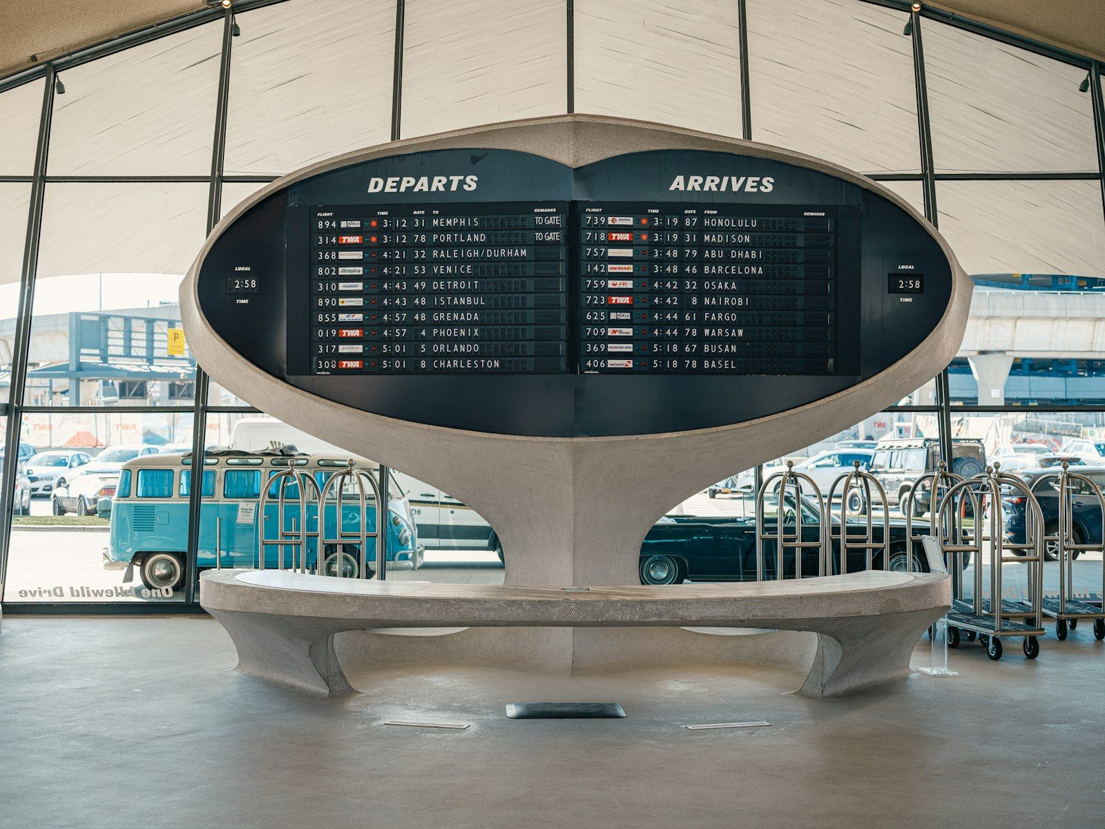 A split-flap departures board, rows of destinations and times set in flipped tiles.